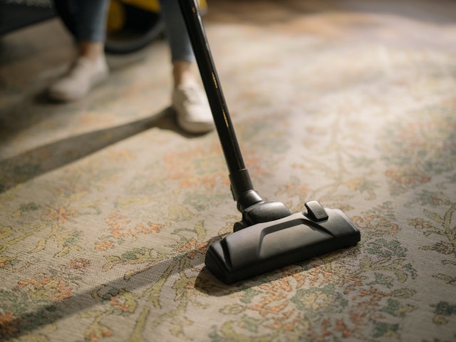Person vacuuming a carpet